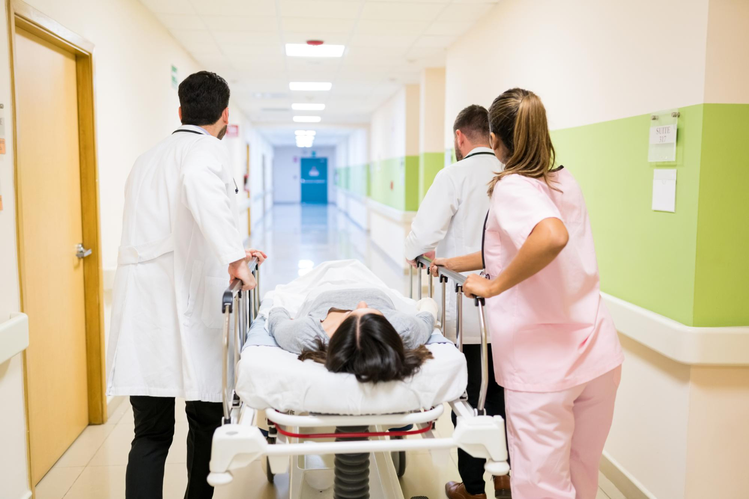 Medical personnel assisting a patient on a stretcher through the bustling hospital corridor, ensuring they receive immediate attention in urgent care.